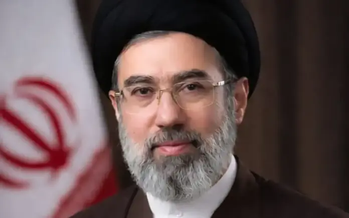 Formal portrait of Mojtaba Khamenei with the Iranian flag in the background