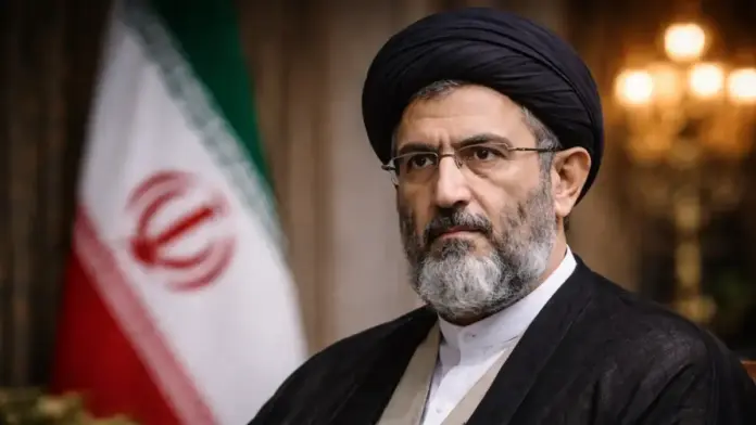 Institutional portrait of Mojtaba Khamenei with the Iranian flag in the background