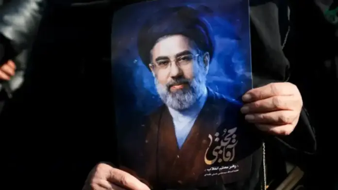 Υποστηρικτής κρατά πορτρέτο του Μοτζτάμπα Χαμενεΐ σε δημόσιο χώρο στο Ιράν